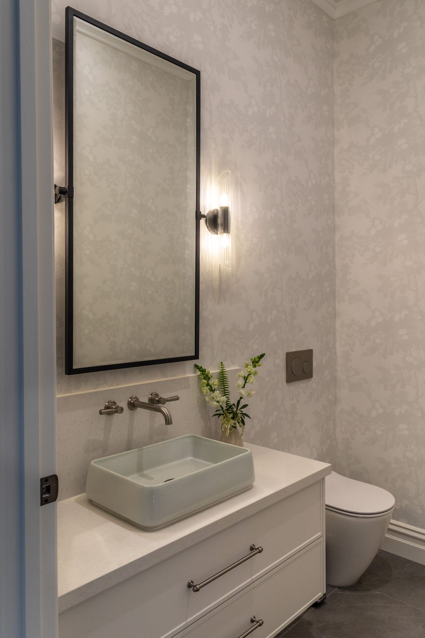 pretty powder room with soft botanical wallpaper